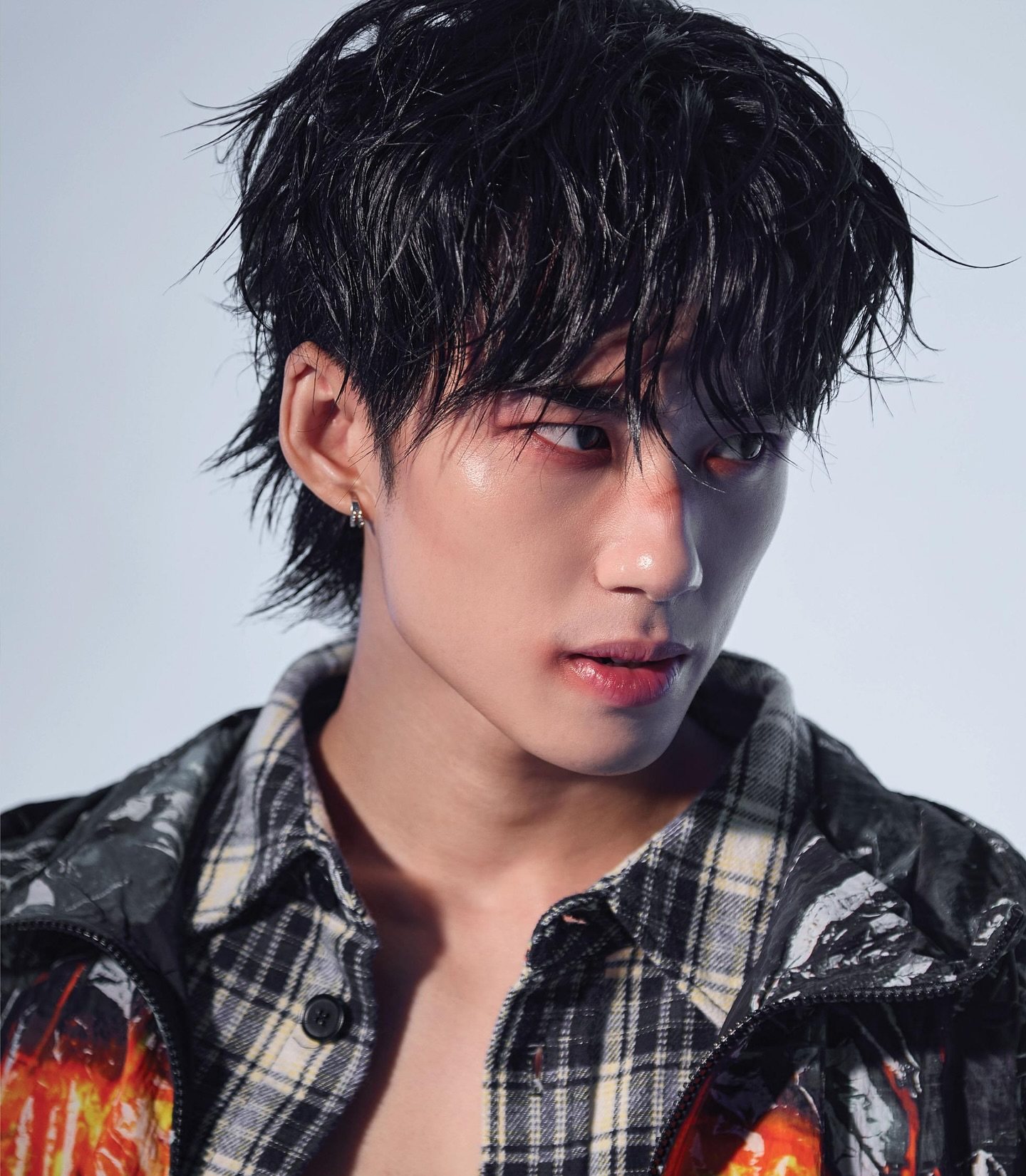 YANG YAN in a studio portrait, wearing a black jacket with an orange flame print